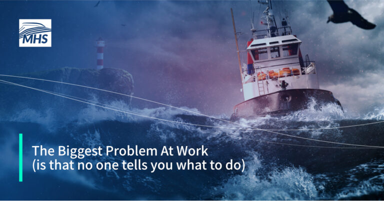 Background image of a ship in rough seas, and a lighthouse in the backdrop, with the words, The Biggest Problem At Work (is that no one tells you what to do).