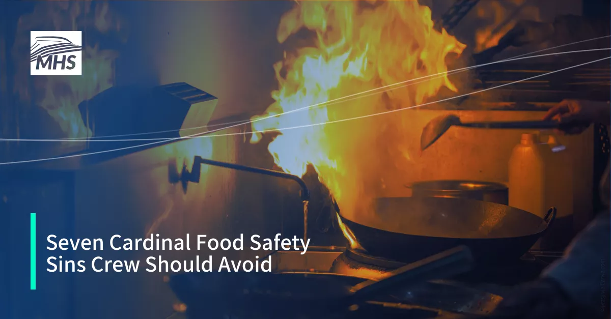 A professional kitchen with a frying pan on fire, with the words, Seven Cardinal Food Safety Sins Crew Should Avoid
