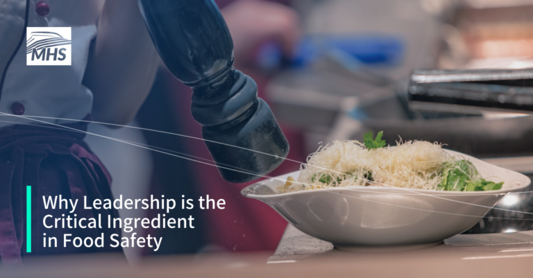 A close-up image of a chef adding salt to caesar salad with the words, Why Leadership is the Critical Ingredient in Food Safety