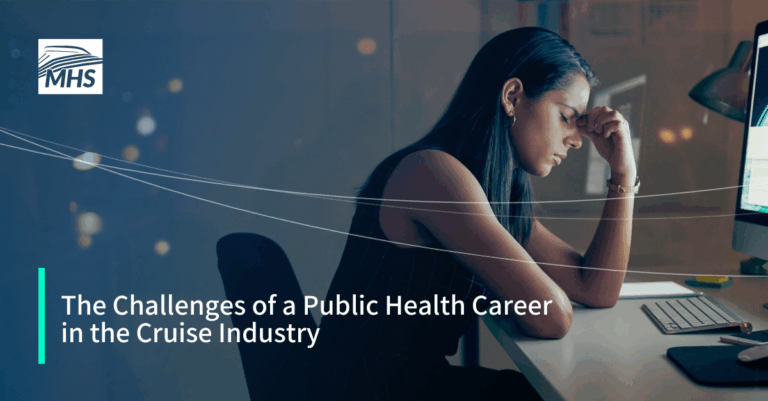 An image of a young businesswoman looking stressed while using a computer at night in a modern office with the words, The Challenges of a Public Health Career in the Cruise Industry
