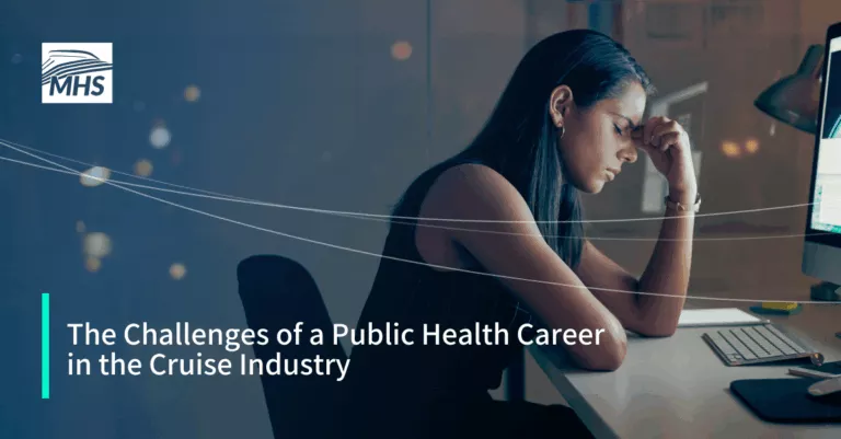 An image of a young businesswoman looking stressed while using a computer at night in a modern office with the words, The Challenges of a Public Health Career in the Cruise Industry