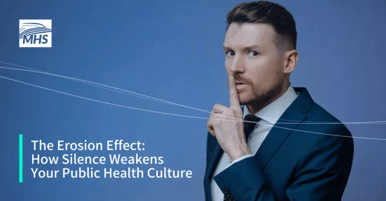 A young businessman in a suit with a finger over his mouth indicating not to speak, with the words, The Erosion Effect How Silence Weakens Your Public Health Culture