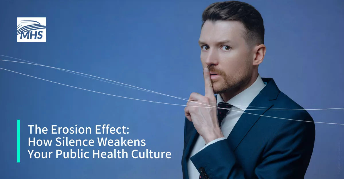 A young businessman in a suit with a finger over his mouth indicating not to speak, with the words, The Erosion Effect How Silence Weakens Your Public Health Culture